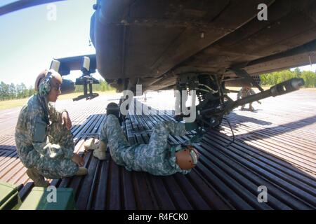 Kampfhubschrauber Reparateure in den 1 Angriff Reconnaissance Bataillon zugeordnet, 82nd Combat Aviation Brigade stellen Sie sicher, dass die Schrauben an der M230 Chain Gun, die eine AH-64D Apache Helikopter befestigt vor dem Flug in Fort Bragg, N.C., 2. Mai angezogen sind. Stockfoto