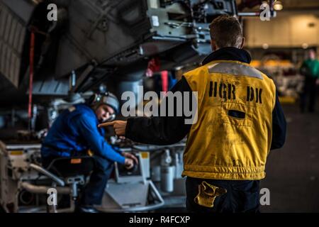 Pazifik (1. Mai 2017) der Luftfahrt Bootsmann Mate (Handling) Airman Adam Torrence Verkehr leitet im Hangar Bucht der Flugzeugträger USS Theodore Roosevelt (CVN 71). Das Schiff ist unterwegs die Durchführung einer Gruppe Sail Training Unit Übung mit dem es Carrier strike Group. Stockfoto