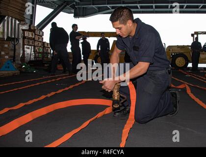 WESTERN PACIFIC (2. Mai 2017) Seemann Anthony Deavila, von Chicago, bereitet ein Löschschlauch zur Überprüfung in der nimitz-Klasse Flugzeugträger USS Carl Vinson (CVN 70) Hangar Bay. Die US-Marine hat die Indo-Asia - Pazifik routinemäßig für mehr als 70 Jahre patrouillierten die Förderung von Frieden und Sicherheit in der Region. Stockfoto