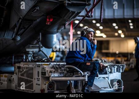 Pazifik (1. Mai 2017) der Luftfahrt Bootsmann Mate (Handling) Airman Matthew Kuhns verwendet einen Traktor zu verlagern, einem MH-60R Sea Hawk Hubschrauber zum 'Battlecats' der Hubschrauber Maritime Strike Squadron (HSM) 73 zugeordnet im Hangar Bucht der Flugzeugträger USS Theodore Roosevelt (CVN 71). Das Schiff ist unterwegs die Durchführung einer Gruppe Sail Training Unit Übung mit dem es Carrier strike Group. Stockfoto