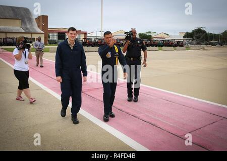 BOSSIER CITY, La-(3. Mai 2017) Navy Flight Demonstration Team, der "Blaue Engel", #7 Crew Chief Aviation Electronics Technician 1. Klasse Anthony Batronis escorts Bossier City Sheriff Detective Mike Lombardino der Barksdale Air Force Base Landebahn Mi., 4. Mai vor dem Rücksitz Ritt des Detective in der Blues' #7 F/A-18 Hornet. Lombardino war unter einer Handvoll "wichtigen Einflussnehmern" für die seltene Ehre ausgewählt. Der Blaue Engel sind die 2017 Verteidiger der Freiheit Air Show führen Künstler, 5. bis 7. Mai geplant. Mehr als 120.000 Zuschauer sind schiefergedeckt zu besuchen. Der Blaue Engel sind zu dedizierten Stockfoto