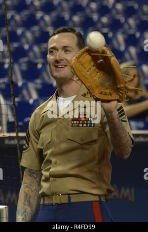 MIAMI, Fla.---- Staff Sgt. Jeremy R. Plympton hilft Konteradmiral Roy I. Kitchener warm up vor der Marlins versus Strahlen baseball spiel bei den Marlins Stadion Mai 2, 2017. Kitchener, dem Kommandeur der Expeditionary Strike Group 2, warf das Spiel öffnen Kugel als Teil der 27. jährlichen Flotte Woche Port Everglades. Whiston, einer von mehr als 100 II Marine Expeditionary Force Marines in der Flotte Woche teilnehmen, ist der Waffen Platoon Sergeant für India Company, 3.BATAILLON, 2. Marine Regiment. Stockfoto