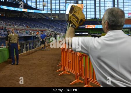 MIAMI, Fla.---- Staff Sgt. Jeremy R. Whiston, Links, hilft Konteradmiral Roy I. Kitchener warm up vor der Marlins versus Strahlen baseball spiel bei den Marlins Stadion Mai 2, 2017. Kitchener, dem Kommandeur der Expeditionary Strike Group 2, warf das Spiel öffnen Kugel als Teil der 27. jährlichen Flotte Woche Port Everglades. Whiston, einer von mehr als 100 II Marine Expeditionary Force Marines in der Flotte Woche teilnehmen, ist der Waffen Platoon Sergeant für India Company, 3.BATAILLON, 2. Marine Regiment. Stockfoto