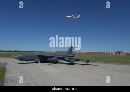 Boeing B-52 H, 60-0005, posiert vor der Oklahoma City Air Logistics komplexe Gebäude. 3001 folgende Generalüberholung während einer Boeing E-6B TACAMO Flugzeuge overhead am 1. Mai 2017 fliegt, Tinker Air Force Base, Oklahoma. OC-ALC ist verantwortlich für das Depot auf Ebene der Wartung der beiden Flotten mit einem großen Teil der Arbeit, die in der Gebäude hinter dargestellt. Stockfoto