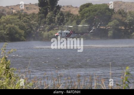 Eine CAL FIRE UH-1H zieht Wasser während der 2017 Wildland Löscheinsatz Übung (WLFFEX) am Lake O'Neil in Camp Pendleton, Kalifornien, 4. Mai 2017. Die WLFFEX ist eine jährliche Veranstaltung der Brandbekämpfung durch den Flugverkehr und Masse Forderungsrisiken aus Marine Corps Installationen - West, Marine Corps Base Camp Pendleton, Dritten Marine Air Wing, Marine Region South West, der Dritten Flotte, CAL FIRE auszuüben, und San Diego County Sheriff's Department. Stockfoto