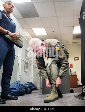 Us Air Force Tech. Sgt. Paul Rosales unterstützt ehemalige Pilot Chesley "Sully" SULLENBERGER III mit ein paar Stiefel vor seinem Flug mit der United States Air Force Thunderbirds bei Travis Air Force Base, Calif., 4. Mai 2017. Sullenberger ist ein 1973 Air Force Academy Absolvent und ist am besten für die erfolgreiche Landung eines verkrüppelten Airliner im Hudson River die Rettung eines 155 Passagiere bekannt. Stockfoto