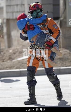 Bayartogtokh Jamsran, Mongolian National Emergency Management Agency Special Rescue Unit, rettet ein Kind aus einem brennenden Gebäude während eines simulierten Rettung übung Mai 4, 2017, in Dalanzadgad, Mongolei als Teil der Gobi Wolf 2017. GW 17 wird veranstaltet von der mongolischen Nationalen Emergency Management Agency und mongolischen Streitkräfte als Teil der humanitären Hilfe der USA Armee Pazifik und Katastrophenhilfe 'Pacific Resilienz'-Serie. Stockfoto