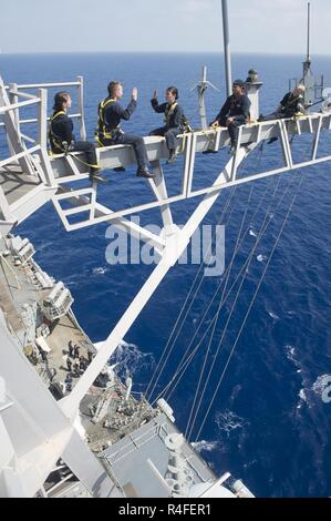 Mittelmeer (3. Mai 2017) Lt.Cmdr. Ben McCarty, zweiter von links, reenlists Information Systems Techniker 2. Klasse Nikki Duffy auf der yardarm der Arleigh-Burke-Klasse geführte Anti-raketen-Zerstörer USS Ross (DDG71). Ross, Vorwärts - Rota, Spanien bereitgestellt werden, ist die Durchführung von naval Operations in den USA 6 Flotte Bereich der Maßnahmen zur Unterstützung der US-amerikanischen nationalen Sicherheitsinteressen in Europa und Afrika. Stockfoto