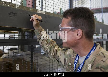 Colonel Tom Palenske, Kommandant der 1. Special Operations Wing, Zeichen einer MC-130J Commando II Flugzeuge Teil bei Lockheed Martin in Crestview, Fla., Okt. 24, 2016. Die Commando II Flotte wird geändert zu AC geworden-130J Ghostrider gunships, Bereitstellung der 1. Leistungsbeschreibung mit verbesserten Close Air Support und Verbot. Stockfoto