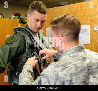 Us Air Force Senior Airman Adam Clapp, rechts, eine flugzeugbesatzung Flug Ausrüstung Techniker aus der 509th Operations Support Squadron, strafft die Riemen der aircrew survival Weste auf Kapitän Daniel Welch, ein B-2 Spirit Pilot die 13 Bomb Squadron zugewiesen, während der Übung Global Donner 17 (GT17) Whiteman Air Force Base, Calif., Okt. 25, 2016. GT 17 ist eine wertvolle Ausbildung Gelegenheit, alle US-Strategic Command mission Bereiche ausüben und die Voraussetzungen für die strategischen Abschreckung gegen eine Vielzahl von Bedrohungen zu erstellen. Stockfoto