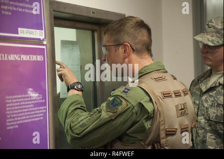 Us Air Force Kapitän James Befugnisse eine B-2 Spirit Piloten mit dem 13 Bomb Squadron, Bewertungen eine Hand den Eingang vor Erhalt der 509th Operations Support Squadron aircrew Flug Ausrüstung (AFE) Shop während der Übung Global Thunder17 am Whiteman Air Force Base, Calif., Okt. 25, 2016. Bevor sie auf ihre Flugzeuge, Piloten haben ihre lebenserhaltenden Geräte aus der AFE-Shop zu erhalten. Stockfoto