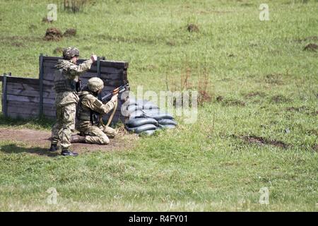 Ein yavoriv Combat Training Center Trainer gibt einen Daumen nach oben, um zu signalisieren, dass die kniende Soldat ist bereit, seine GP-25 Granatwerfer während der Ausbildung an der Yavoriv CTC auf der internationalen Friedens und der Sicherheit, in der Nähe der Yavoriv, der Ukraine, die auf Feuer, am 3. Mai. CTC-Trainer, mit Soldaten der 45Th der US Army Infantry Brigade Combat Team zusammengeschlossen, sind Lehre Truppen der 1. der ukrainischen Armee Airmobile Bataillon, 79 Air Assault Brigade wie der Granatwerfer während defensive Operationen während der Drehung des Bataillons im CTC zu beschäftigen. Der 45 IBCT ist als Teil von Th bereitgestellt Stockfoto