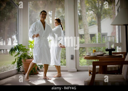 Mitte - erwachsene Paare tanzen beim Tragen von Bademänteln. Stockfoto