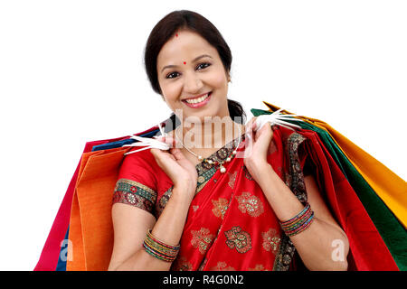 Lächelnden jungen traditionelle Frau mit Einkaufstüten Stockfoto