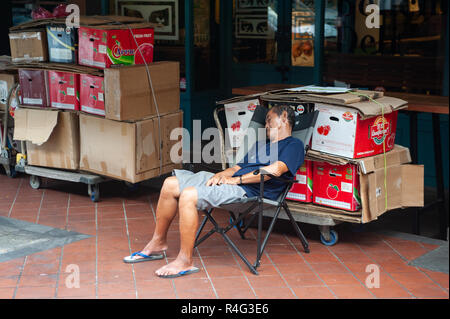 29.07.2018, Singapur, Republik Singapur, Asien - Ein alter Mann sitzt auf einem Stuhl in Singapur Chinatown und hält ein Nickerchen. Stockfoto