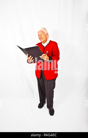 Lächelnd attraktive ältere Frau in einem Buch lesend und eine Rede Stockfoto