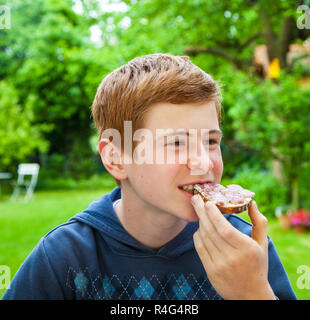 Junge essen ein Brot Stockfoto