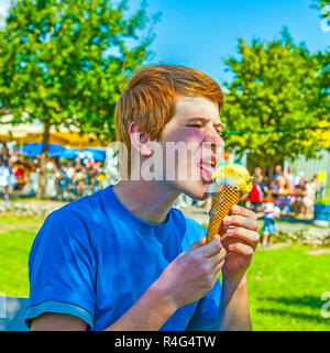Cute boy leckt ein Eis in den Park an einem heißen Sommertag Stockfoto