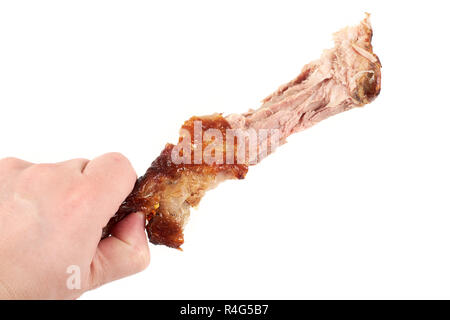 Close Up und isolierte Bild von Hand eine Holding knabberte Türkei Bein auf weißem Hintergrund. Stockfoto