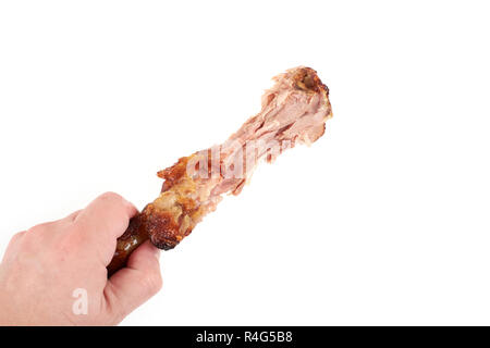 Close Up und isolierte Bild von Hand eine Holding knabberte Türkei Bein auf weißem Hintergrund. Stockfoto