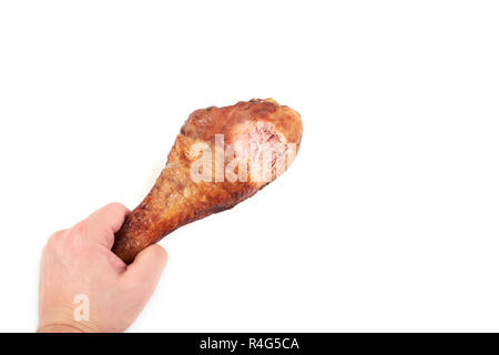 Hand mit gebratener Truthahn Bein mit Biss, auf weißem Hintergrund. Stockfoto