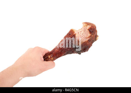 Hand, die Hähnchen Bein mit Biss, auf weißem Hintergrund. Stockfoto