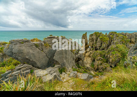 Felsformationen an der Steilküste des Pazifischen oceanon ein bewölkter Tag. punakaiki Pancake Rocks, West Coast, Neuseeland Stockfoto