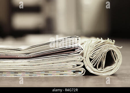 Zeitungen und Zeitschriften gefaltet und gerollt und in Haufen gestapelt, tabloid Zeitschriften mit Nachrichten und geschäftliche Informationen und Daten, Vintage Style, Seitenansicht Stockfoto