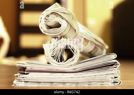 Zeitungen und Zeitschriften gefaltet und gerollt und in Haufen gestapelt, tabloid Zeitschriften mit Nachrichten und geschäftliche Informationen und Daten, Vintage Style, Seitenansicht Stockfoto