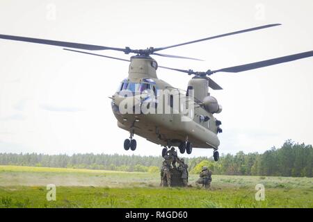 Soldaten auf das erste Bataillon zugeordnet, 319 Airborne Field Artillery Regiment, 82nd Airborne Division Artillerie eine Munition Container auf dem Bauch des CH-47F Chinook Hubschrauber vom 3. Allgemeine Unterstützung Aviation Battalion, 82nd Combat Aviation Brigade während Schlinge Ladevorgänge in Fort Bragg, N.C., Mai 4. Stockfoto