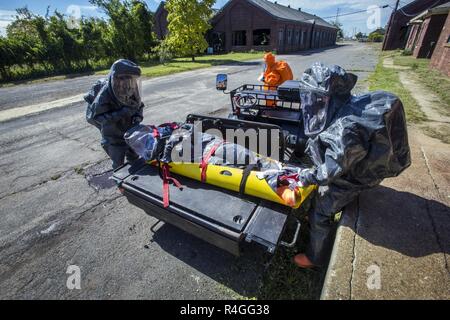 Us-Armee Umfrage Teammitglied Staff Sgt. Nicky Lam, Links, und Sgt. Joseph A. Bercovic, rechts, Last simuliert verletzt Sgt. Koran Williams, Mitte, während Sgt. Tricia C. Madrigal behält Gewahrsam von simulierten Beweise am Tatort, die alle mit 21 Massenvernichtungswaffen Destruction-Civil Support Team, New Jersey der National Guard, der während einer Übung am Fort Hancock und Sandy Hook Proving Ground National Historic Landmark, Sandy Hook, New Jersey, Sept. 25, 2018. Das 21 WMD-CST Unterstützung der zivilen Behörden bei Man-made oder Naturkatastrophen durch die Identifizierung von chemischen, biologischen, radiologischen und nuklearen subst Stockfoto