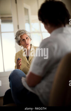 Reife weibliche Rechtsanwalt hat eine intensive Diskussion mit Ihrem Kunden in Ihrem sonnigen Büro. Stockfoto