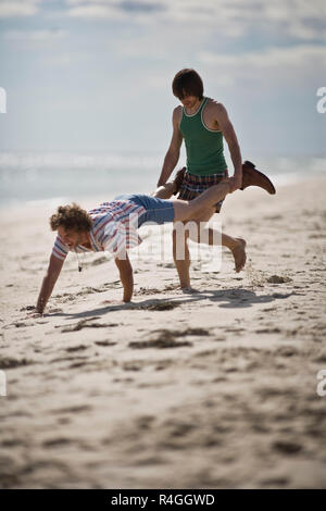 Junge Männer spielen am Strand Stockfoto