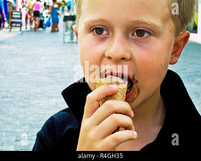 Junge Eis essen und genießt es Stockfoto