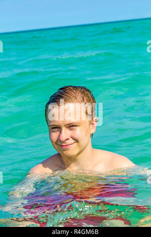 Stattliche jugendlich hat Spaß das Schwimmen im Meer Stockfoto