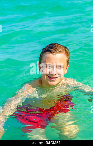 Stattliche jugendlich hat Spaß das Schwimmen im Meer Stockfoto