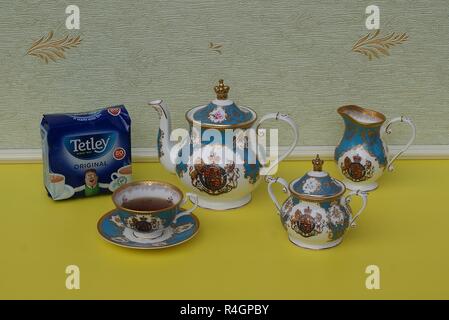 Ein Paket von Original englischer Tetley Teebeutel neben einer englischen Teetasse mit Untertasse, Teekanne, Zuckerdose und Sahne Kanne, Fine Bone China Porzellan Stockfoto