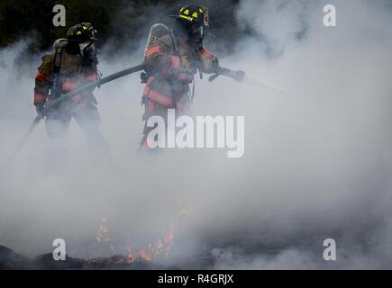 96. Test Wing Feuerwehrmänner Schlacht Feuer um eine simulierte Hubschrauberabsturz während einer Messe Unfallversicherung Übung 3 in Eglin Air Force Base, Fla. Die gemeinschaftsweite übung tief in den Eglin Bereich umfasste 96 TW Ersthelfer, 6 Ranger Training Bataillon Personal, Okaloosa County Ersthelfer unter anderem. Die übung ausgewertet Ranger Aktionen und Base und lokale Antworten auf beide ein Blitzschlag und Absturz eines Hubschraubers. Stockfoto