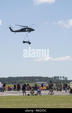 Menschenmassen beobachten Soldaten aus der Alpha Company, 2-149 th Allgemeine Unterstützung Aviation Battalion, 1-111 th Aviation Regiment ein UH-60 Black Hawk ein Humvee während der South Carolina National Guard in der Luft und am Boden Expo bei McEntire Joint National Guard Base, South Carolina, 7. Mai 2017 zur Luftbrücke. Diese Expo ist eine kombinierte Waffen Demonstration der Fähigkeiten der South Carolina National Guard und Soldaten und sagen Danke für die Unterstützung von Kollegen Südcarolinians und der umgebenden Gemeinschaft. Stockfoto