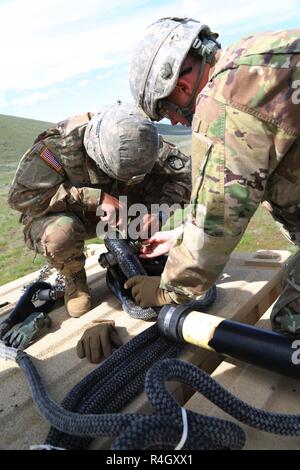 Us-Armee Sgt. Patrick Walsh und Sgt. Deron Englisch, 21 Chemical Company, 83. Chemische Bataillon, 48. Chemische Brigade, bereiten ein Container für eine Schlinge Ladevorgang an der Yakima Training Center, Yakima, Washington, 5. Mai 2017. Sling laden lassen Einheiten ihre Mission durch schnelle Verlegung Lieferungen und Ausrüstung, ohne Hindernisse zu erreichen. Stockfoto