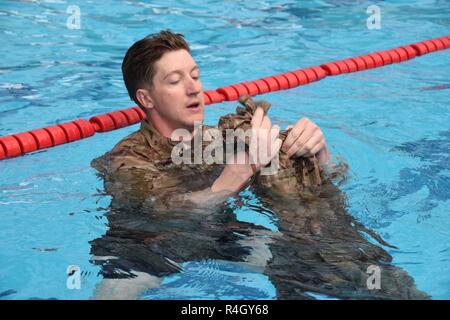 Warrant Officer David Hobart, auf die 2.Infanterie Division Sustainment Brigade zugeordnet, bereitet seine Hose zu einer Flotation Gerät während des Wasser Überlebensfähigkeit Herausforderung am dritten Tag des 2-ID/RUCD besten Krieger Wettbewerb im Camp Casey, April 11. Die 2 Infantry Division ist die Durchführung einer einwöchigen besten Krieger Wettbewerb zu identifizieren und den herausragenden Offizier, Warrant Officer, Unteroffizier erkennen, junior Soldat Soldat, und koreanischen Augmentation der United States Army (KATUSA) innerhalb der Division. Stockfoto