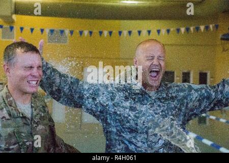Sgt. 1. Klasse Josua Hankle und Kaplan Jason Davis zu 3 Bataillon zugeordnet, 15 Infanterie Regiment, 2. gepanzerte Brigade Combat Team, mit Wasser, bevor Sie in den Pool für Bekämpfung der Überlebenstraining in Fort Stewart, Ga. Bei Johnson Fitnessraum, Sept. 27 gesprüht. CWST lehrt Soldaten, wie man kämpft und im Wasser gewinnen Kampf Umgebungen. Stockfoto
