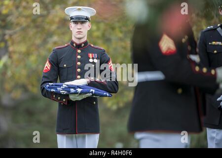 Ein Marine aus dem Marine Kaserne, Washington, D.C. (8. und ich) hält eine gefaltete US-Flagge während der militärischen Ehren mit einer Beerdigung Beerdigung escort für vier Marines und einem Seemann, der während des Vietnam Krieges in Abschnitt 60 von Arlington National Cemetery, Arlington, Virginia, Sept. 27, 2018 starb. Denen, die in einer Gruppe Beerdigung repatriiert wurden Kapitän John House, II; Lance Cpl. John Killen, III; Cpl. Glyn Runnels, Jr.; und Lance Cpl. Merlin Allen, allen US Marine Corps, sowie U.S. Navy Hospital Corpsman Michael Judd. Von der Verteidigung POW/MIA Accounting Agentur News Release: Juni 30, 1967, Haus Stockfoto