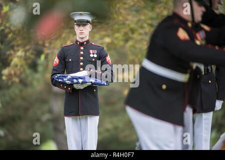 Ein Marine aus dem Marine Kaserne, Washington, D.C. (8. und ich) hält eine gefaltete US-Flagge während der militärischen Ehren mit einer Beerdigung Beerdigung escort für vier Marines und einem Seemann, der während des Vietnam Krieges in Abschnitt 60 von Arlington National Cemetery, Arlington, Virginia, Sept. 27, 2018 starb. Denen, die in einer Gruppe Beerdigung repatriiert wurden Kapitän John House, II; Lance Cpl. John Killen, III; Cpl. Glyn Runnels, Jr.; und Lance Cpl. Merlin Allen, allen US Marine Corps, sowie U.S. Navy Hospital Corpsman Michael Judd. Von der Verteidigung POW/MIA Accounting Agentur News Release: Juni 30, 1967, Haus Stockfoto