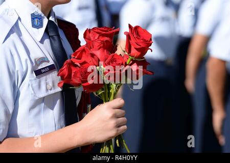 Ein jüngeres Vorbehalten Officers' Training Corps Student aus Rancho High School hält einen Strauß Rosen am Freiheit Feld auf der Nellis Air Force Base, Nev., Sept. 21, 2018. Eine rote Rose symbolisiert das Blut, dass ein Genosse geopfert hat und die Hoffnung, dass Familie und Freunde haben, dass sie eines Tages nach Hause zurückkehren. Stockfoto