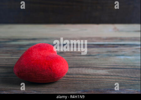 Red Velvet Herz liegen auf einem rustikalen Holzmöbeln Oberfläche. Saint Valentines Tag, liebe Karte, Banner, Nachricht Konzept. Stockfoto