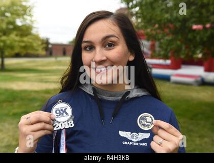 Airman Olivia Simione, 92nd Air Refuelling Flügel religiöse Angelegenheiten Kaplan Assistant, wirft mit Medaillon der CMSAF Binnicker9K's Memorial Run Heftstation und einem 50-jährigen Jubiläum Luftwaffe Soldaten Dorf Gedenkmünze am Miller Park in Fairchild Air Force, Washington, Sept. 22, 2018. Die AFEV ist eine gemeinnützige Organisation, deren Hauptaufgabe ist ein sicheres Zuhause für survivng Ehegatten von pensionierten Soldaten Flieger zur Verfügung zu stellen. Stockfoto