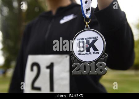 Airman 1st Class Desteny Zuniga, 92nd Comptroller Squadron Unit Manager, hält Medaillon ist ein finisher sie nach Ausführen des CMSAF Binnicker9K Memorial Run am Miller Park in Fairchild Air Force Base, Washington, Sept. 22, 2018. Die AFEV ist eine gemeinnützige Organisation, deren Ziel es ist, ein sicheres Zuhause für überlebende Ehegatten von pensionierten Soldaten Flieger zur Verfügung zu stellen. Stockfoto