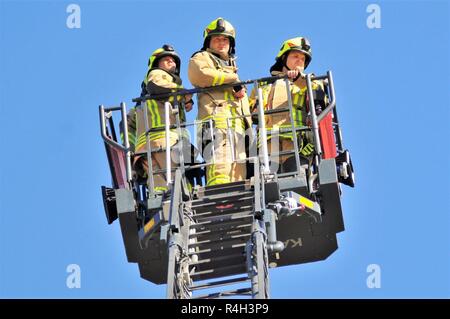 Zivile Feuerwehrmänner Andreas Vogel, Links, Jonas Grossmueller, Mitte, und Henrik Maurer, Rechts, von der Feuerwehr Ansbach die Evakuierung und die Rettungsmaßnahmen, bei Katterbach Kaserne, Deutschland, Sept. 27, 2018 demonstrieren. Stockfoto