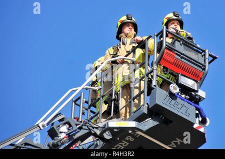 Zivile Feuerwehrmänner Jonas Grossmueller, Links, und Henrik Maurer, Rechts, von der Feuerwehr Ansbach die Evakuierung und die Rettungsmaßnahmen, bei Katterbach Kaserne, Deutschland, Sept. 27, 2018 demonstrieren. Stockfoto